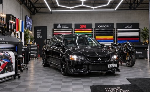 Evo IX et sportive dans l’atelier GXS Racing — vue de trois-quarts